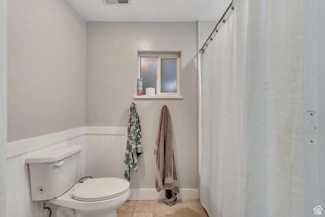 719 E Center St, Genola, UT 84655 - bathroom with toilet, tile patterned flooring, a shower with curtain, and wainscoting