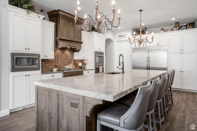 2699 S 2000 E, St George, UT 84790 - kitchen featuring built in appliances, a chandelier, a sink, backsplash, and a spacious island