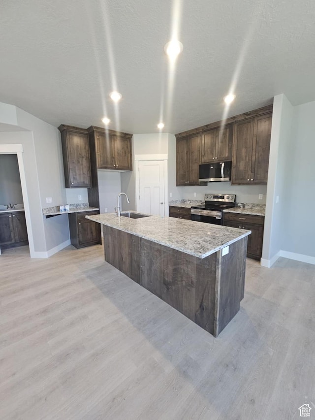 1192 W 1130 S Unit 202, Payson, UT 84651 - kitchen featuring appliances with stainless steel finishes, baseboards, dark brown cabinetry, a sink, and a kitchen island with sink