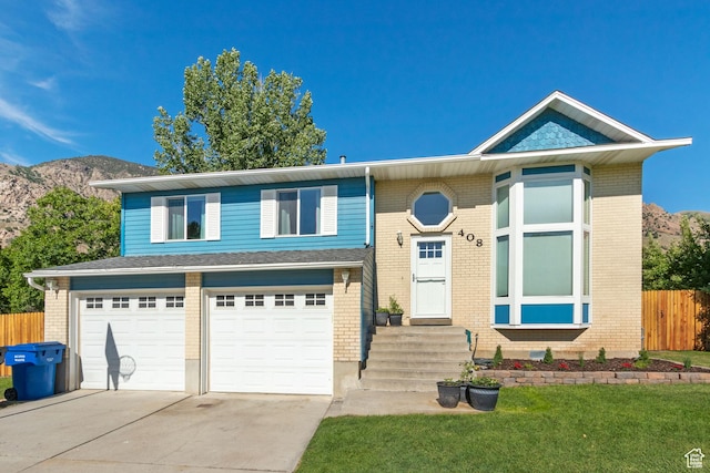 408 E 850 N, Brigham City, UT 84302 - view of front facade with a garage, driveway, a mountain view, and brick siding