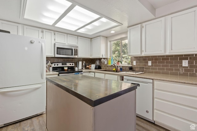 408 E 850 N, Brigham City, UT 84302 - kitchen with stainless steel appliances, a sink, decorative backsplash, white cabinets, and light wood finished floors