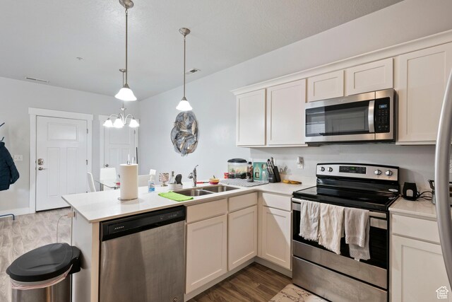 633 N Sun Peak Dr, Vineyard, UT 84059 - kitchen featuring appliances with stainless steel finishes, a sink, a peninsula, dark wood finished floors, and light countertops