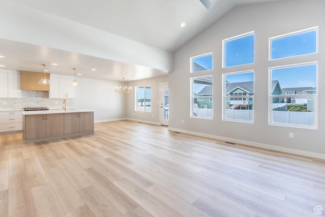 3087 N 2875 W Unit 4, Plain City, UT 84404 - unfurnished living room featuring light wood finished floors, a chandelier, recessed lighting, and high vaulted ceiling