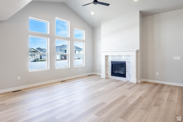 3087 N 2875 W Unit 4, Plain City, UT 84404 - unfurnished living room with a ceiling fan, plenty of natural light, a glass covered fireplace, light wood finished floors, and high vaulted ceiling