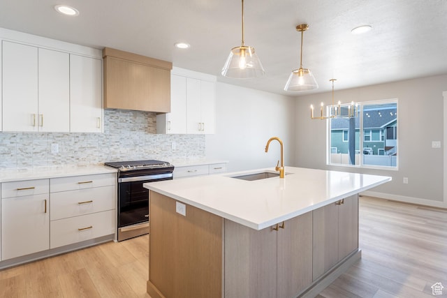 3087 N 2875 W Unit 4, Plain City, UT 84404 - kitchen with stainless steel range with gas stovetop, light wood-style flooring, tasteful backsplash, light countertops, and a center island with sink