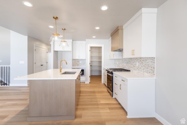 3087 N 2875 W Unit 4, Plain City, UT 84404 - kitchen with range with gas stovetop, an island with sink, light wood-style flooring, backsplash, and recessed lighting