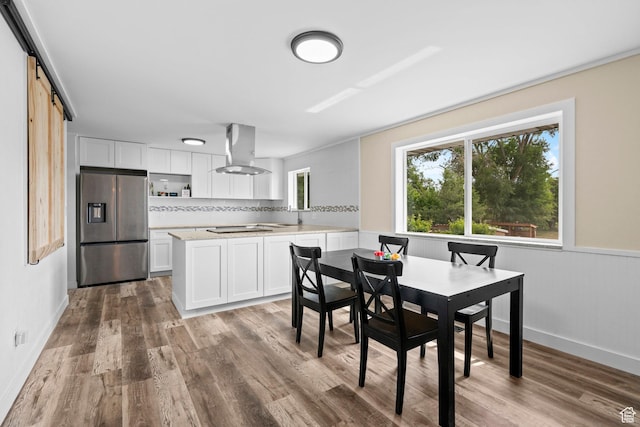 12345 S Redwood Rd, Riverton, UT 84065 - dining room with wood finished floors, baseboards, and a barn door