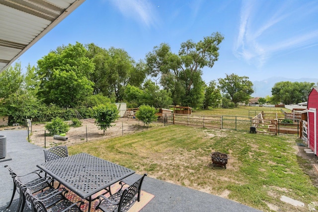 12345 S Redwood Rd, Riverton, UT 84065 - view of yard featuring a fire pit, outdoor dining space, central air condition unit, and an outbuilding