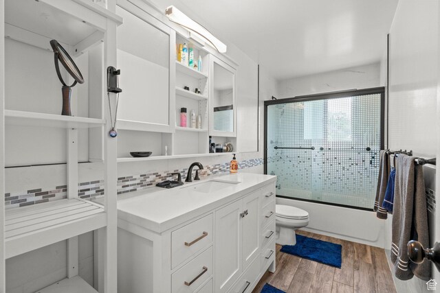12345 S Redwood Rd, Riverton, UT 84065 - bathroom featuring toilet, combined bath / shower with glass door, vanity, wood finished floors, and decorative backsplash