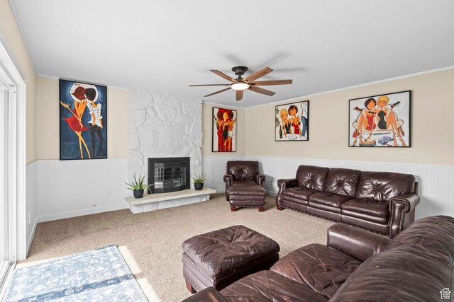 12345 S Redwood Rd, Riverton, UT 84065 - living area with carpet, a ceiling fan, a wainscoted wall, a stone fireplace, and crown molding