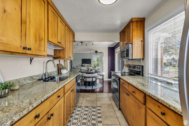 6 W Miller St S, Salt Lake City, UT 84107 - kitchen featuring stainless steel appliances, a ceiling fan, brown cabinetry, and light stone countertops