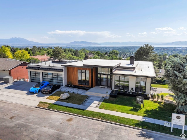 3943 N Foothill Dr, Provo, UT 84604 - contemporary home featuring a mountain view, concrete driveway, a front yard, and a chimney