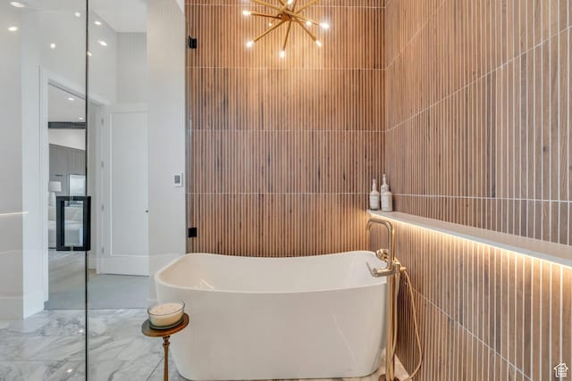 3943 N Foothill Dr, Provo, UT 84604 - bathroom with a freestanding tub, a chandelier, marble finish flooring, and tile walls
