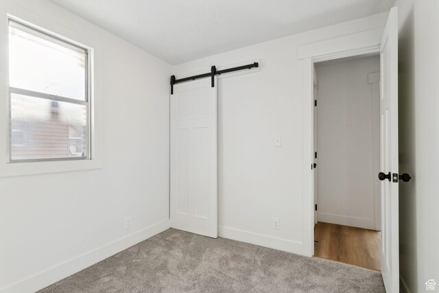 155 W 800 N, Spanish Fork, UT 84660 - unfurnished bedroom featuring baseboards, light colored carpet, and a barn door