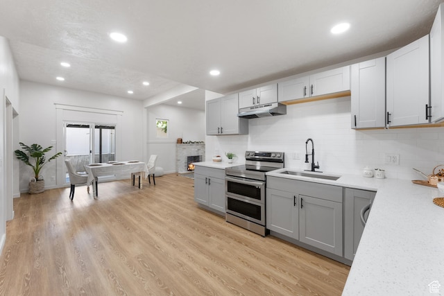 2802 W 5600 S, Roy, UT 84067 - kitchen with range with two ovens, a sink, under cabinet range hood, gray cabinetry, and recessed lighting