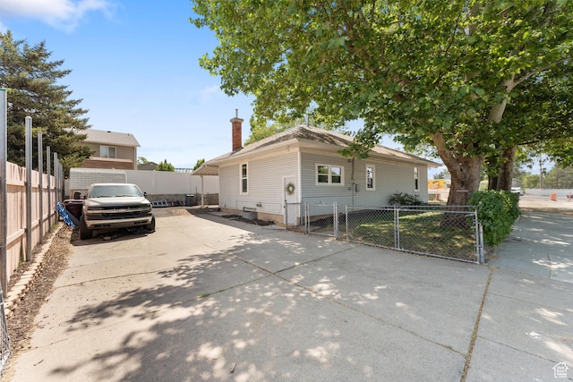 2802 W 5600 S, Roy, UT 84067 - view of front of house featuring a chimney, concrete driveway, and a gate