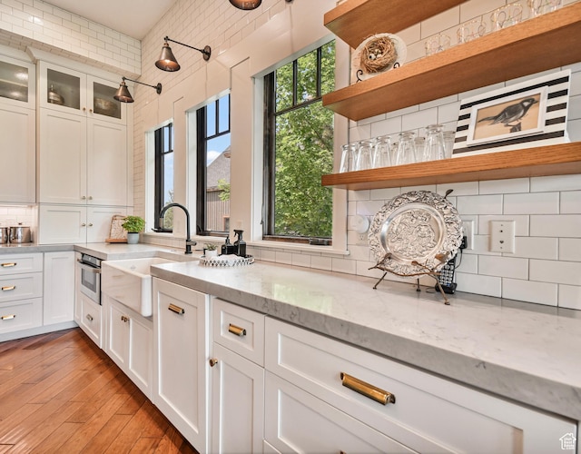 707 N Chimney Rock Rd, Heber City, UT 84032 - kitchen with open shelves, backsplash, a sink, white cabinetry, and light stone counters
