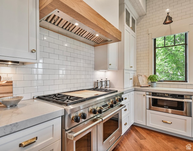 707 N Chimney Rock Rd, Heber City, UT 84032 - kitchen featuring range with two ovens, premium range hood, white cabinetry, tasteful backsplash, and glass insert cabinets