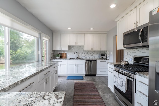 1820 E Meadow Dr S, Cottonwood Heights, UT 84121 - kitchen with appliances with stainless steel finishes, decorative backsplash, recessed lighting, white cabinetry, and light stone counters