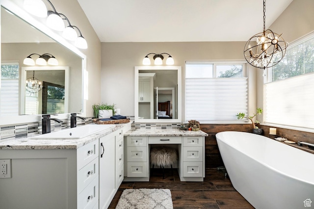 13898 Summerset Cir, Draper, UT 84020 - bathroom featuring a chandelier, vanity, a freestanding bath, lofted ceiling, and wood finished floors