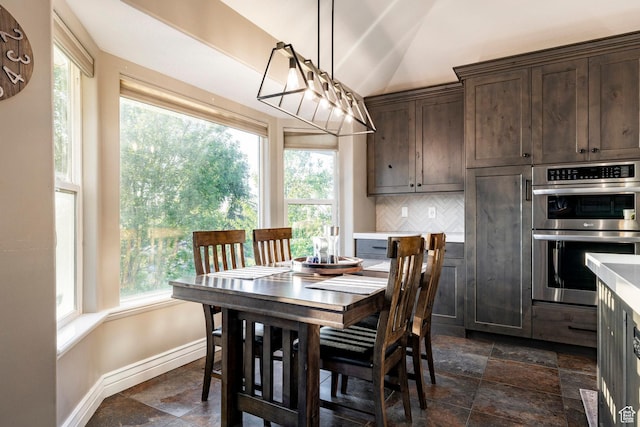 13898 Summerset Cir, Draper, UT 84020 - dining area featuring stone tile flooring, baseboards, healthy amount of natural light, and lofted ceiling