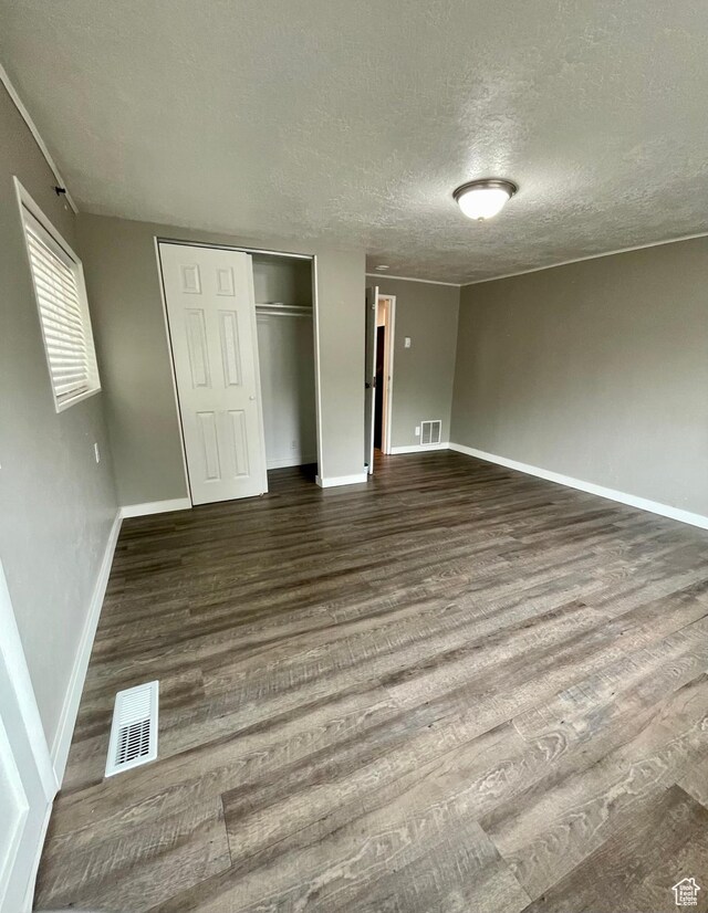 947 W 1300 N, Carbonville, UT 84501 - unfurnished bedroom featuring wood finished floors, a textured ceiling, baseboards, and a closet