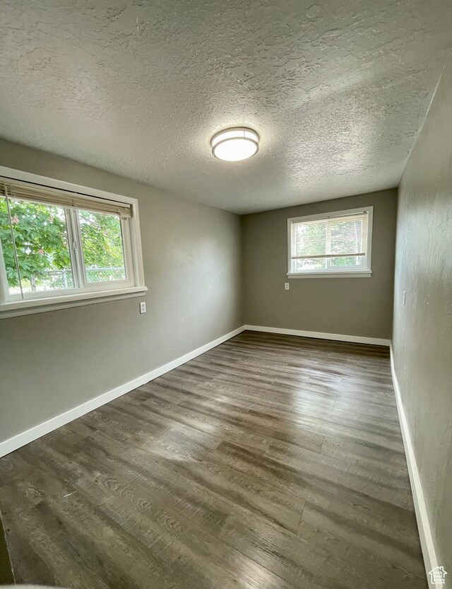 947 W 1300 N, Carbonville, UT 84501 - empty room with healthy amount of natural light, wood finished floors, a textured ceiling, and baseboards