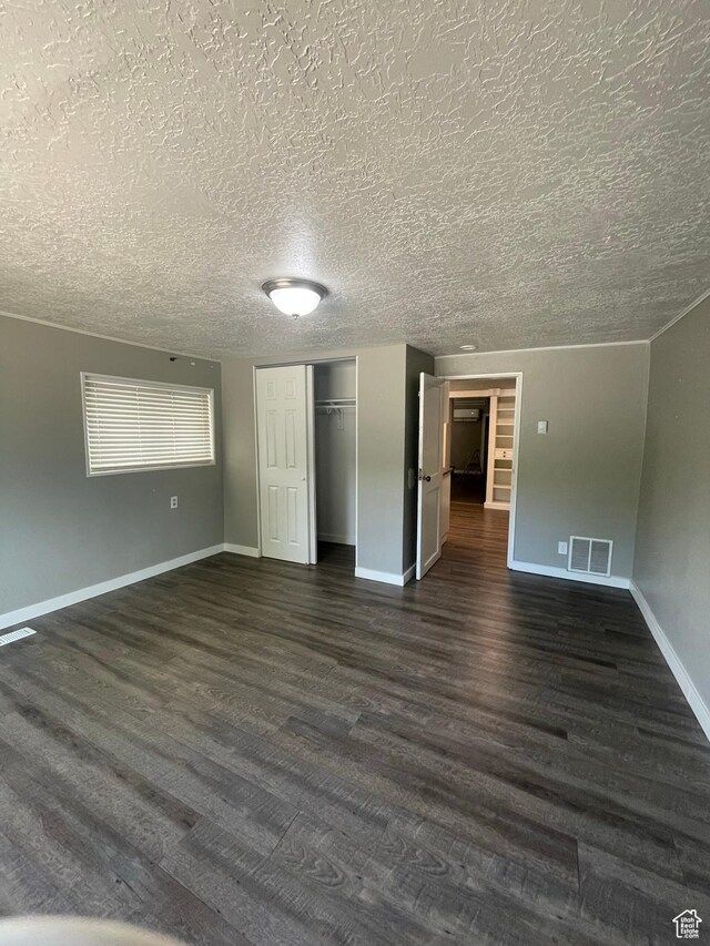 947 W 1300 N, Carbonville, UT 84501 - unfurnished bedroom with dark wood-type flooring, a textured ceiling, baseboards, and a closet