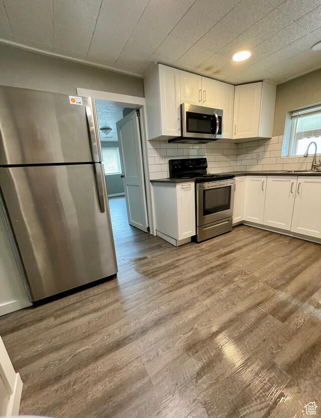 947 W 1300 N, Carbonville, UT 84501 - kitchen featuring appliances with stainless steel finishes, dark countertops, white cabinetry, wood finished floors, and recessed lighting