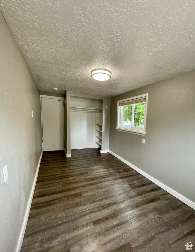 947 W 1300 N, Carbonville, UT 84501 - unfurnished bedroom featuring dark wood finished floors, baseboards, a closet, and a textured ceiling