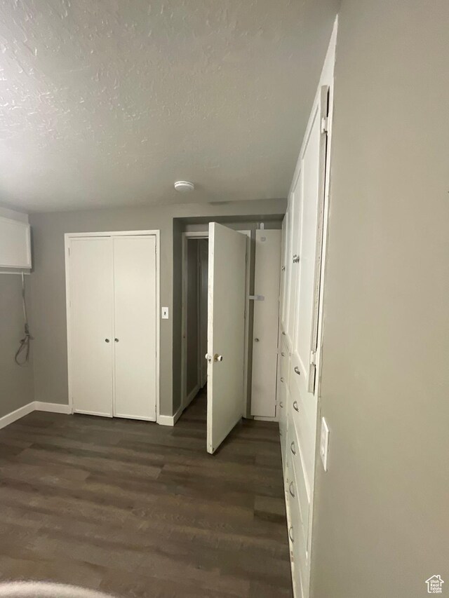 947 W 1300 N, Carbonville, UT 84501 - unfurnished bedroom with dark wood-style floors, a textured ceiling, and baseboards