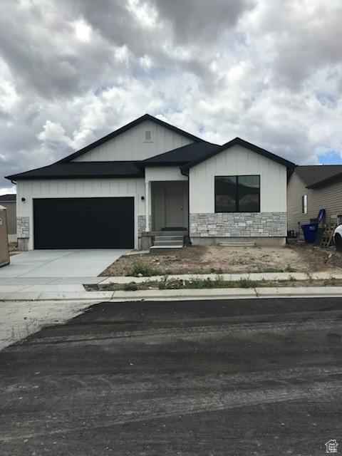 1515 N 250 E, Nephi, UT 84648 - view of front of property featuring stone siding, a garage, driveway, and board and batten siding