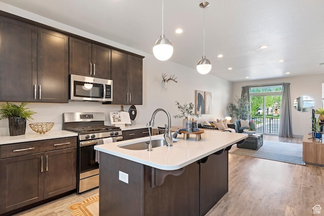 1940 S 200 W Unit 11, Bountiful, UT 84010 - kitchen with stainless steel appliances, open floor plan, light countertops, dark brown cabinetry, and light wood finished floors