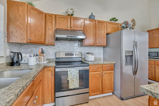 4564 S Early Duke St, West Valley City, UT 84120 - kitchen featuring under cabinet range hood, appliances with stainless steel finishes, light wood-type flooring, and tasteful backsplash