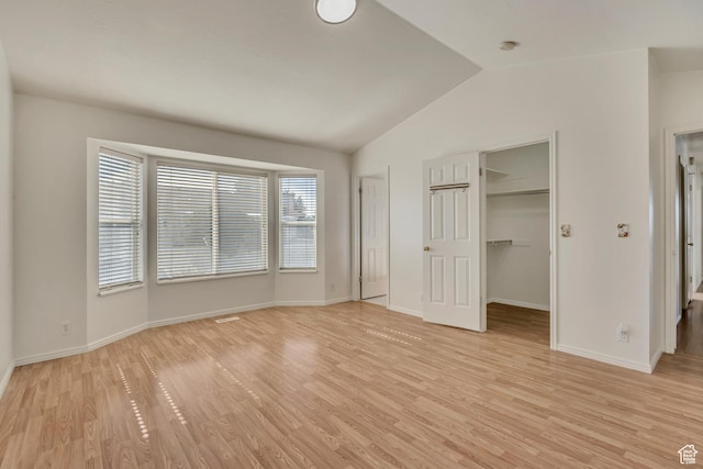 4564 S Early Duke St, West Valley City, UT 84120 - unfurnished bedroom featuring vaulted ceiling, light wood-type flooring, baseboards, a walk in closet, and a closet