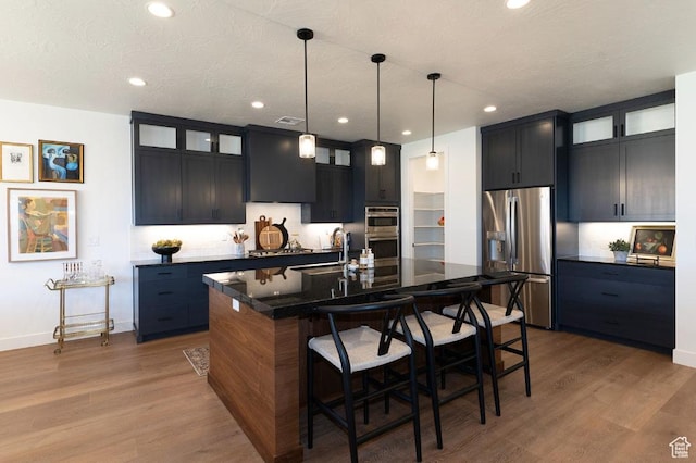 1367 N Daylight St Unit 16, Washington, UT 84780 - kitchen with stainless steel appliances, a breakfast bar area, wood finished floors, glass insert cabinets, and recessed lighting