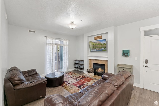 1063 S 500 E Unit B101, Heber City, UT 84032 - living area featuring a textured ceiling, wood finished floors, a tile fireplace, and baseboards