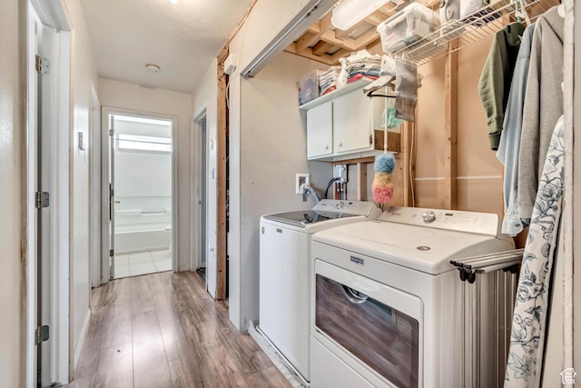 2172 White Pine Rd, Eagle Mountain, UT 84005 - laundry room featuring washing machine and clothes dryer, light wood-style floors, and cabinet space