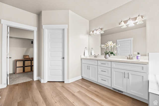 9447 N Arrowhead Dr, Eagle Mountain, UT 84005 - full bathroom featuring double vanity, wood finished floors, and baseboards