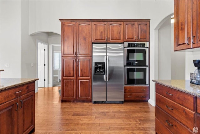150 N 1015 W, Manti, UT 84642 - kitchen featuring stainless steel appliances, arched walkways, light stone countertops, and light wood-type flooring