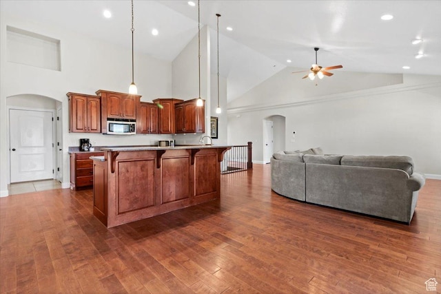 150 N 1015 W, Manti, UT 84642 - kitchen with stainless steel microwave, arched walkways, a kitchen breakfast bar, a ceiling fan, and high vaulted ceiling