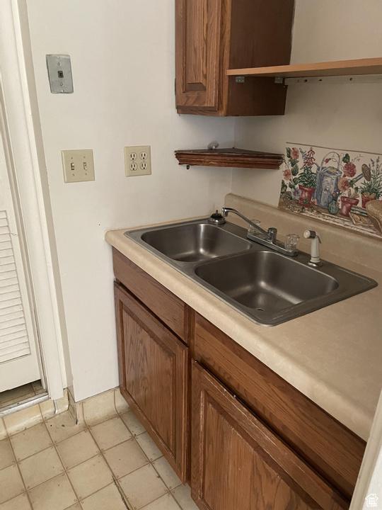 133 W Forest St, Brigham City, UT 84302 - kitchen featuring open shelves, a sink, light countertops, brown cabinets, and light tile patterned floors