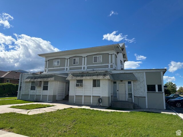 133 W Forest St, Brigham City, UT 84302 - view of front facade featuring brick siding and a front yard