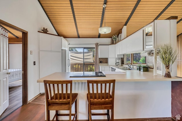 1063 Oxford Dr, Ogden, UT 84403 - kitchen with a peninsula, freestanding refrigerator, wooden ceiling, dark wood-style floors, and light countertops