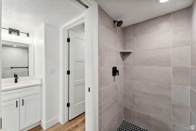 622 E 340 S, American Fork, UT 84003 - bathroom featuring a textured ceiling, vanity, a tile shower, and wood finished floors