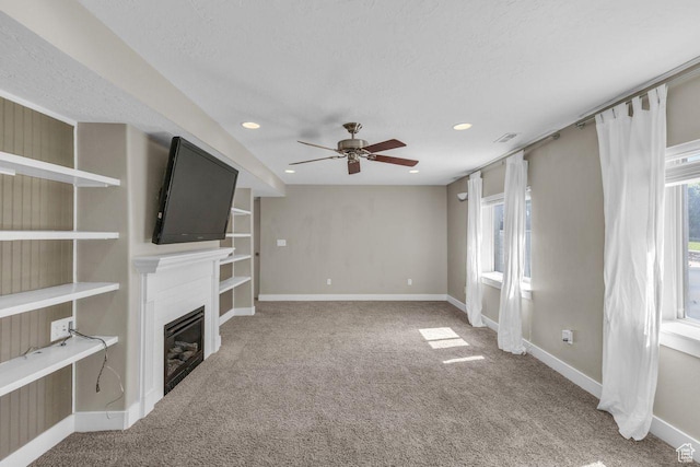 1848 W 645 S, Orem, UT 84059 - unfurnished living room featuring carpet, a ceiling fan, a glass covered fireplace, baseboards, and plenty of natural light
