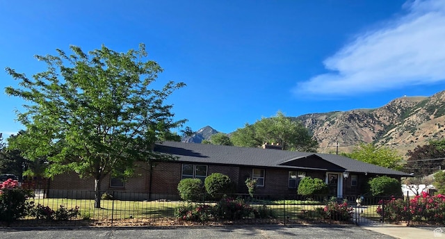 611 E 100 N, Brigham City, UT 84302 - view of front of property with a fenced front yard, brick siding, and a mountain view