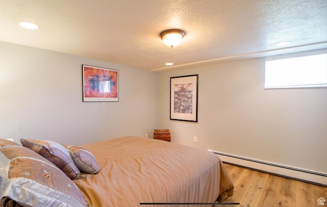 331 W Elberta Dr, Pleasant View, UT 84414 - bedroom with baseboard heating, wood finished floors, a textured ceiling, and recessed lighting