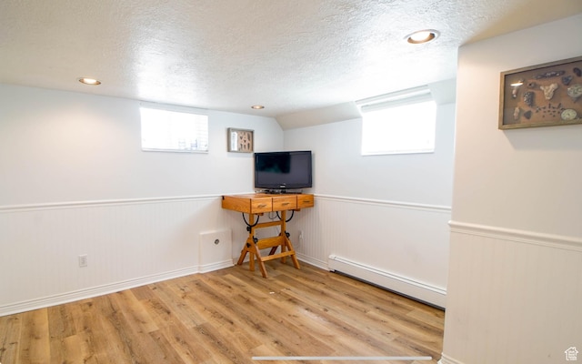 331 W Elberta Dr, Pleasant View, UT 84414 - below grade area with a baseboard radiator, a textured ceiling, wood finished floors, wainscoting, and plenty of natural light