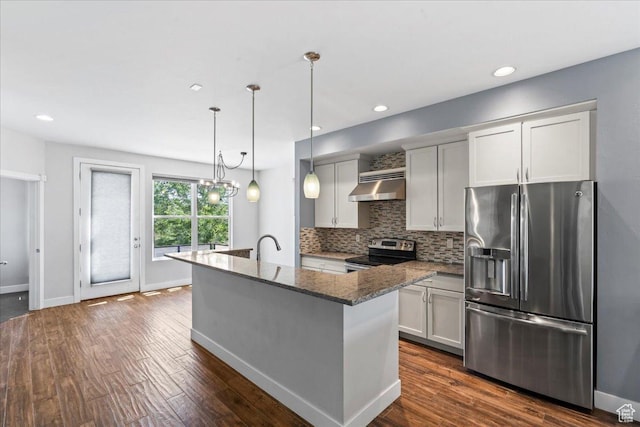 4746 W S Jordan Pkwy, South Jordan, UT 84009 - kitchen with appliances with stainless steel finishes, under cabinet range hood, backsplash, dark stone counters, and an island with sink
